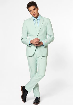 Helles mintgrünes Anzug, taillierte Passform, einreihige Jacke, mit passenden Hosen und hellblauem Hemd, ergänzt durch schwarze Schuhe.