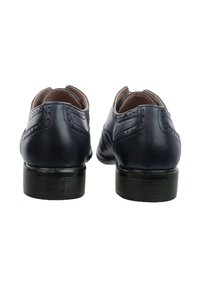 Zapatos de cuero azul oscuro con un acabado suave, punta redonda y detalles decorativos de brogue, con un tacón de madera negro.