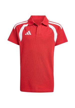 Garçon debout et souriant, portant un t-shirt de sport rouge à manches courtes avec des rayures blanches et un pantalon de sport noir.