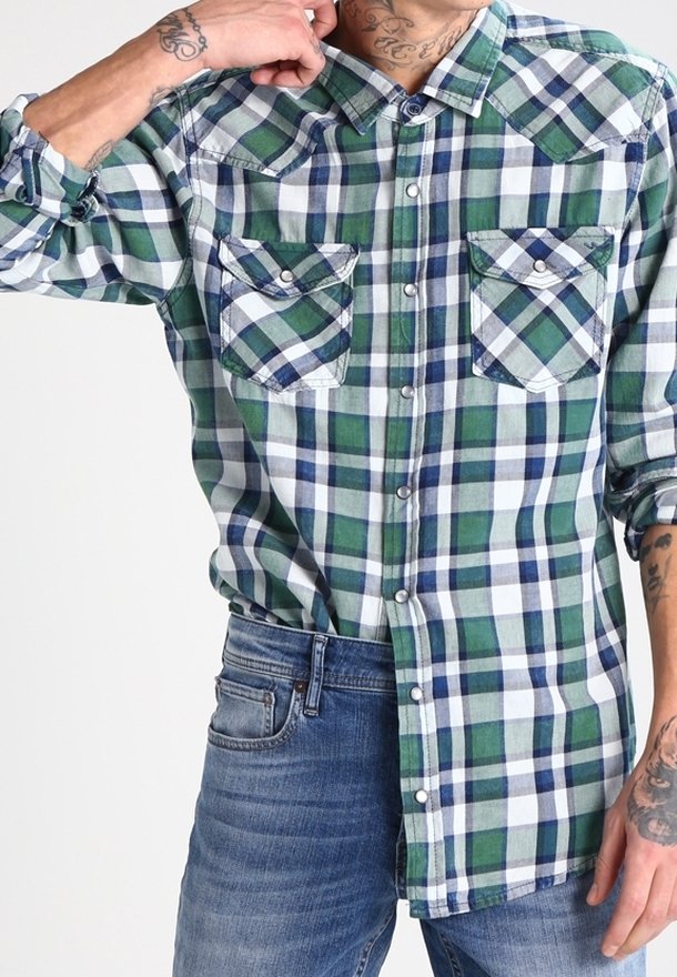 Camisa de franela a cuadros verdes y azules con mangas largas y dos bolsillos en el pecho; presenta botones blancos y un cuello redondeado.