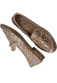 Mocassins tissés beiges avec des accents métalliques, talon bas et sangle décorative. Tissu texturé avec une légère brillance, taille 38, doublure intérieure lisse.