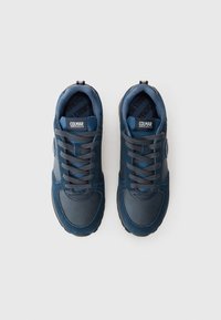 Blauwe sport sneakers met een mix van gladde en suede texturen. Voorzien van ronde veters, gewatteerde kraag en een logo op de tong. Rubberen zool.