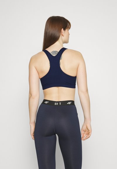 Navy sports bra with a racerback design, smooth fabric, and a snug fit. Comes with high-waisted navy leggings featuring a black waistband.
