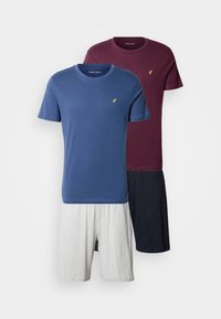 Deux t-shirts en coton bleu marine et bordeaux, avec un petit logo doré ; assortis à des shorts blancs et bleu marine.