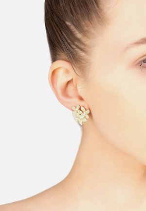Gold-tone floral stud earring with clustered leaves, adorned with clear crystals, set against a light background.