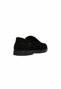Chaussures slip-on en suede noir avec un bout arrondi, une semelle en caoutchouc basse et des détails de couture minimalistes. Présente un logo discret sur le côté.