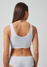 Grauer Baumwoll-Sport-BH mit Rundrücken und breiten Trägern, kombiniert mit passenden grauen Slips. Glatte Textur, unauffälliges Design.