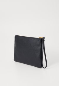 Pochette en cuir noire. Surface texturée avec une fermeture éclair et une sangle de poignet. Forme rectangulaire minimaliste.