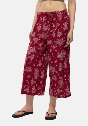 Pantaloni leggeri a fiori rossi con vita media, elastico in vita e coulisse. Stile culotte con una vestibilità rilassata.