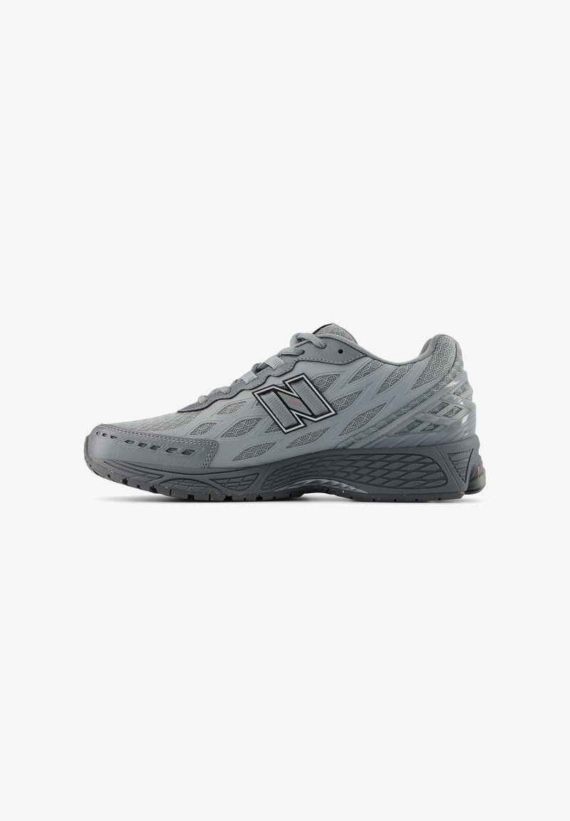 Chaussure de sport New Balance grise avec dessus en mesh, fermeture à lacets et semelle texturée, vue de profil sur fond blanc.