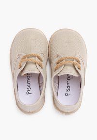 Chaussures en toile beige à bout rond, avec des lacets beige, une surface texturée et des semelles de couleur claire. Le nom de la marque "Pisamonas" est visible à l'intérieur.