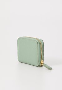 Portafoglio quadrato verde menta realizzato in pelle testurizzata, con una zip dorata e un piccolo cordino in pelle per una facile apertura.