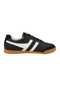Sneaker nera realizzata in pelle testurizzata con strisce diagonali bianche, una suola in gomma e dettagli in suede nera sulla punta e sul tallone.