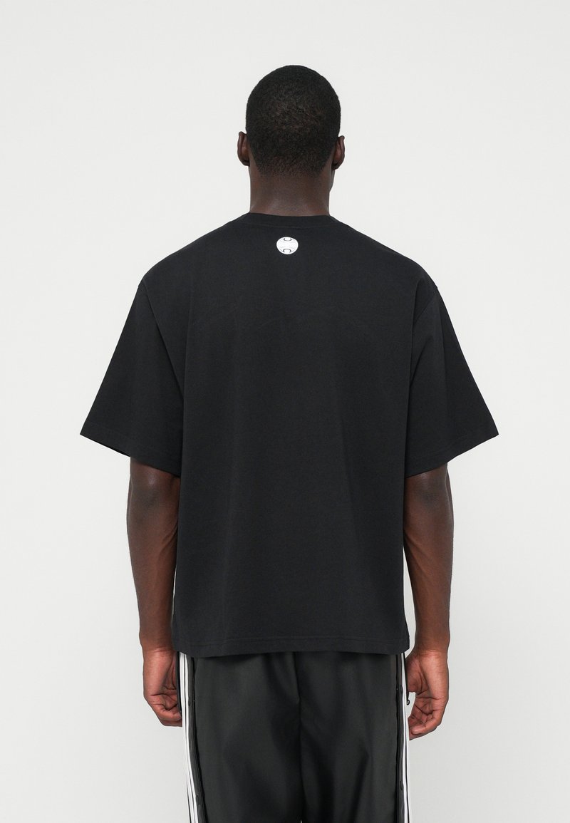 Camiseta corta negra con mangas cortas, cuello redondo y un pequeño logo en la parte trasera. Fabricada en un tejido suave con un corte relajado.