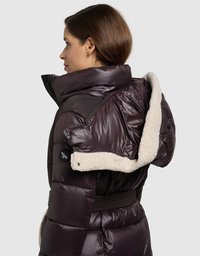 Ciemnofioletowa kurtka puchowa z futrzanym kołnierzem, o teksturowanym wykończeniu, taliowana, z widocznymi guzikami na ramieniu.