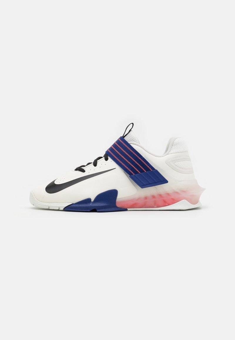 Chaussure de sport blanche avec le logo Nike noir, bride bleue avec coutures rouges et semelle translucide avec dégradé rouge.