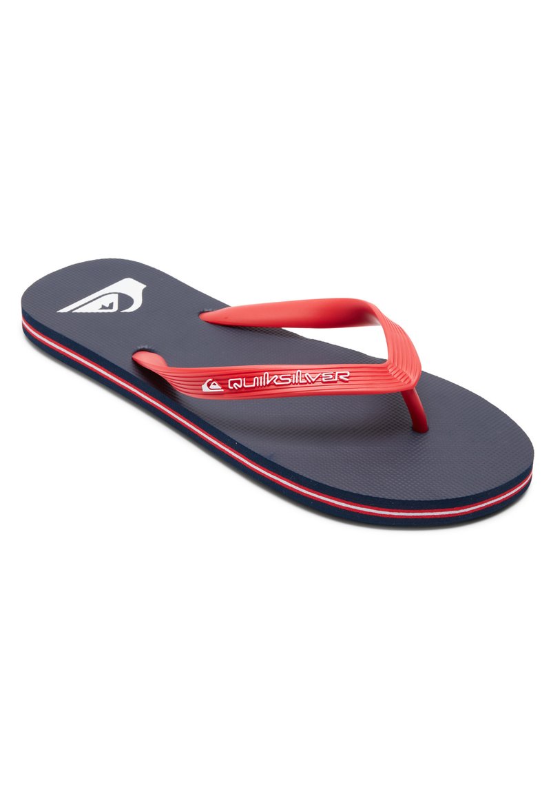 Tongs bleu marine avec des accents et des straps rouges. Présente un semelle texturée et un design de logo subtil sur le dessous.