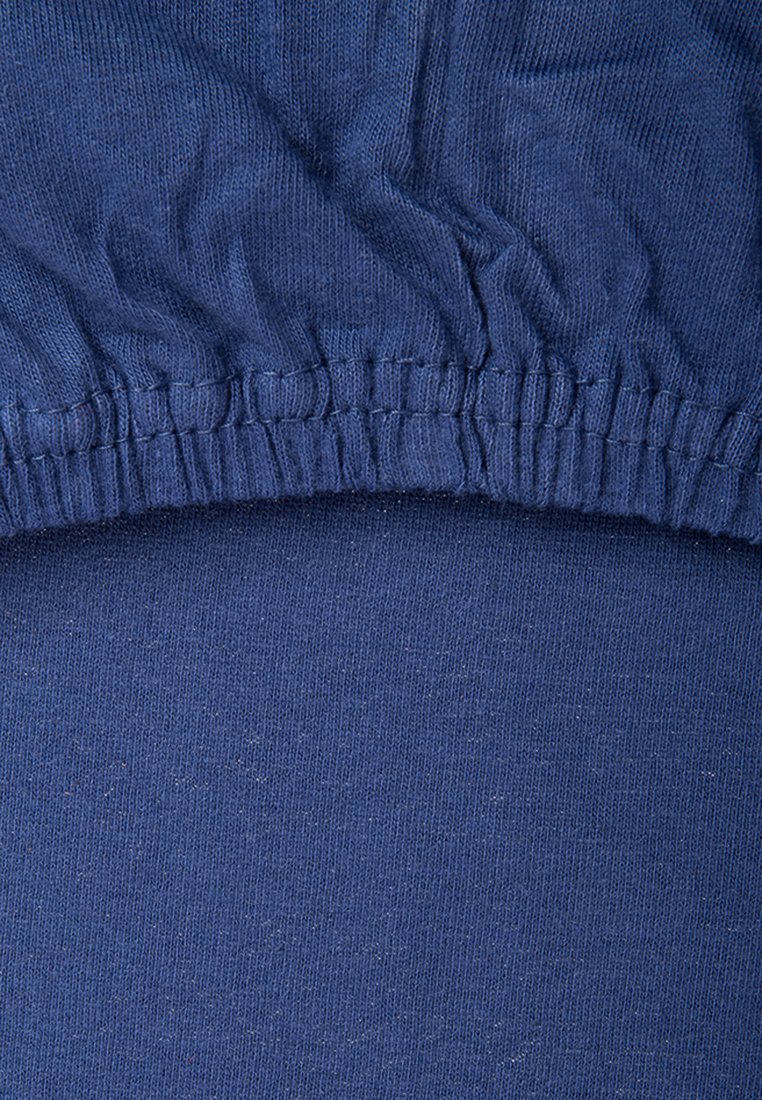 Marineblauer Stoff mit glatter Textur und elastischem Bund, der oben gerafft ist. Einfarbig mit gleichmäßiger Dicke durchgehend.