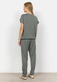 Grå matchende sæt bestående af en løs kortærmet top og bukser med elastisk talje. Blødt stof med en afslappet pasform og minimalistisk design.