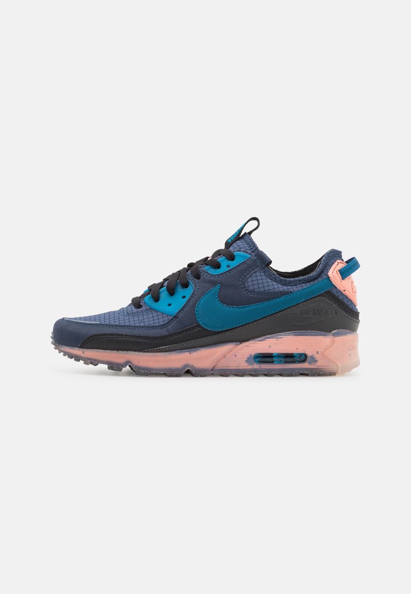 Chaussure de course bleu marine et bleu sarcelle avec lacets noirs, semelle intermédiaire pêche et coussin d'air visible sur fond blanc, vue de profil.