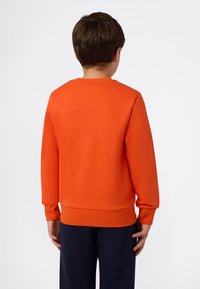 Pomarańczowy sweatshirt z długimi rękawami i okrągłym dekoltem. Wykonany z miękkiego materiału, charakteryzujący się ściągaczem na dole oraz gładką fakturą.