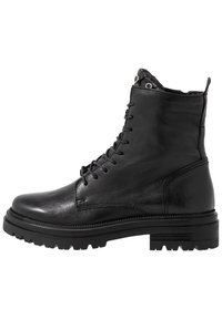 Stivali ankle in pelle nera con lacci, caratterizzati da una suola in gomma nera spessa, tomaia texturizzata e occhielli in metallo per i lacci.