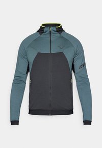 Kapucnis sportdzseki, elöl cipzárral, sötétszürke és teal színkombinációval, sima tapintású anyaggal és neon sárga részletekkel.