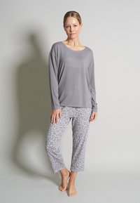 Gray long-sleeve top with a round neck paired with light gray leopard print cropped pants. Smooth fabric, relaxed fit, no visible hardware.
