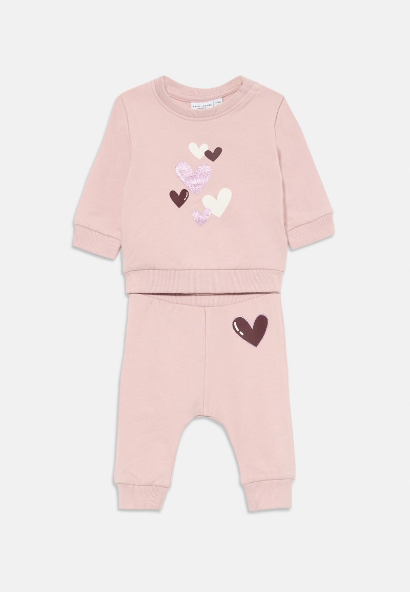 Roza dolg rokav oblačilo za otroke z bleščicami in trdnimi srčkami na zgornjem delu ter temnim srčkom na hlačah.
