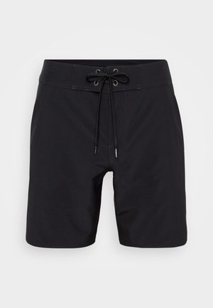 Mustad must ujumispüksid, millel on paelaga vöökoht, lühike pikkus ja sile kangatekstuur. Omab tugevat õmblust ja silmadega augusid nööride jaoks.