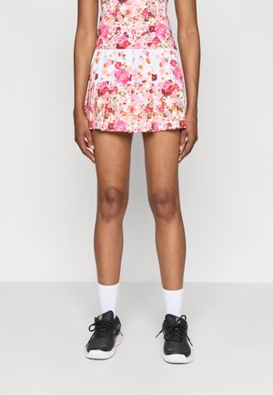 Blomstrete plissert skjørt med rosa, røde og hvite mønstre, kombinert med svarte joggesko og hvite ankelstrømper.