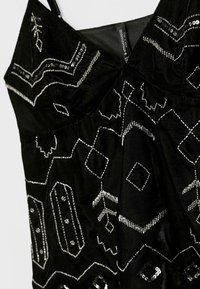 Schwarzes Kleid mit filigranen silbernen Perlenmustern. Hergestellt aus einem strukturierten Stoff mit einem taillierten Oberteil und verstellbaren Trägern.