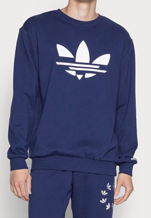 Felpa blu navy con logo bianco Adidas, dotata di colletto a giro e maniche lunghe. Il materiale ha una texture liscia; il design è a vestibilità comoda.