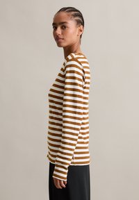 Gestreepte langarmshirt in bruin en wit katoen, met een ronde halslijn en een relaxte pasvorm, voorzien van zijsplitten en mouwlengte tot de pols.