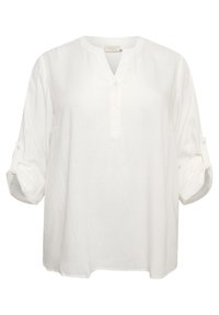 Chemise en lin blanche, légère, avec une texture douce, patte de boutonnage courte et manches à rouleaux, offrant une coupe décontractée et un col rond.