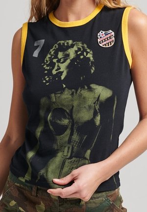 Black sleeveless top with yellow trim featuring a vintage graphic print and a badge, displaying a figure in a corset design.