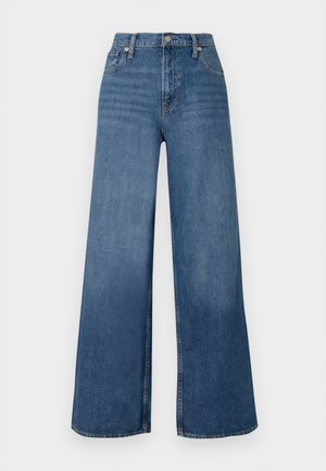 Platas kājas zilas džinsus, kas izgatavoti no denima, ar augstu jostu, priekšējo pogu aizdari un klasisko piecu kabatu dizainu. Gluda tekstūra.