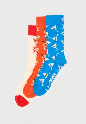 Drei bunte Socken mit Cocktailmotiven: rot und cremefarben mit Getränken und "cin cin", orange mit verschiedenen Cocktails und blau mit Martinis.
