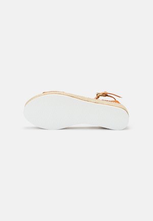 Sandale espadrille beige avec une semelle en jute tressé, des brides texturées beige et une semelle extérieure en caoutchouc blanc. Elle est dotée d'une fermeture à boucle pour un ajustement optimal.