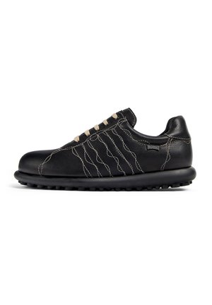 Black leather shoe with cream stitching, round toe, laced design, and textured sole with rounded grips, offering a casual, sporty look.
