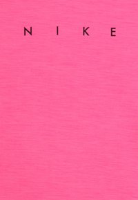 Rosa tyg har ordet "NIKE" tryckt i fet svarta bokstäver. Texturen ser slät ut med en subtil glans.