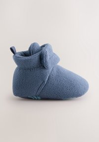Chausson bébé en polaire bleu doux avec détail visage d'ours en tissu et fermeture latérale à bande auto-agrippante, conçu pour le confort et la chaleur.