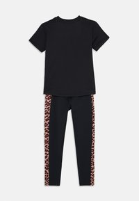 T-shirt noir à manches courtes associé à un legging noir avec des panneaux latéraux en imprimé léopard. Fabriqué en tissu doux et extensible pour plus de confort.