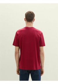 Rød bomulds t-shirt med korte ærmer, en rund hals og en lige kant. Enkel design, glat tekstur og ingen synlige logoer eller mønstre.