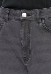 Jeans de mezclilla gris oscuro con cierre frontal de botón, diseño de bolsillos estándar y un acabado sutilmente texturizado.