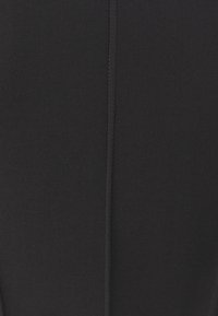 Black ribbed fabric with a smooth texture and vertical seam detail, creating a fitted silhouette. No visible patterns or hardware.