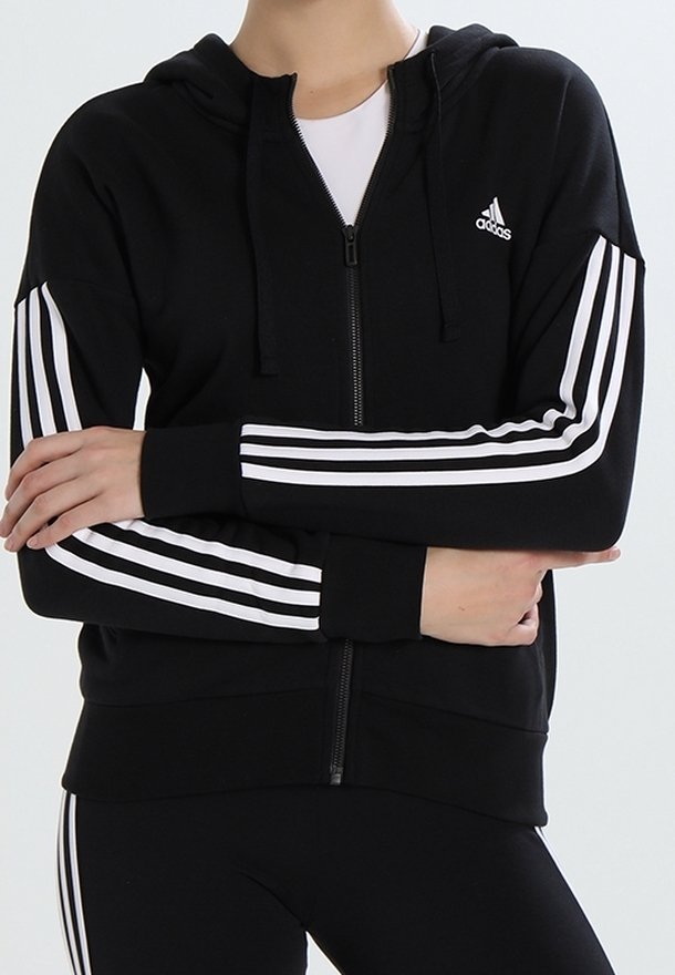 Sweat à capuche noir zippé en tissu doux, avec des rayures blanches sur les manches et un petit logo en haut à gauche. Capuche avec cordon de serrage incluse.