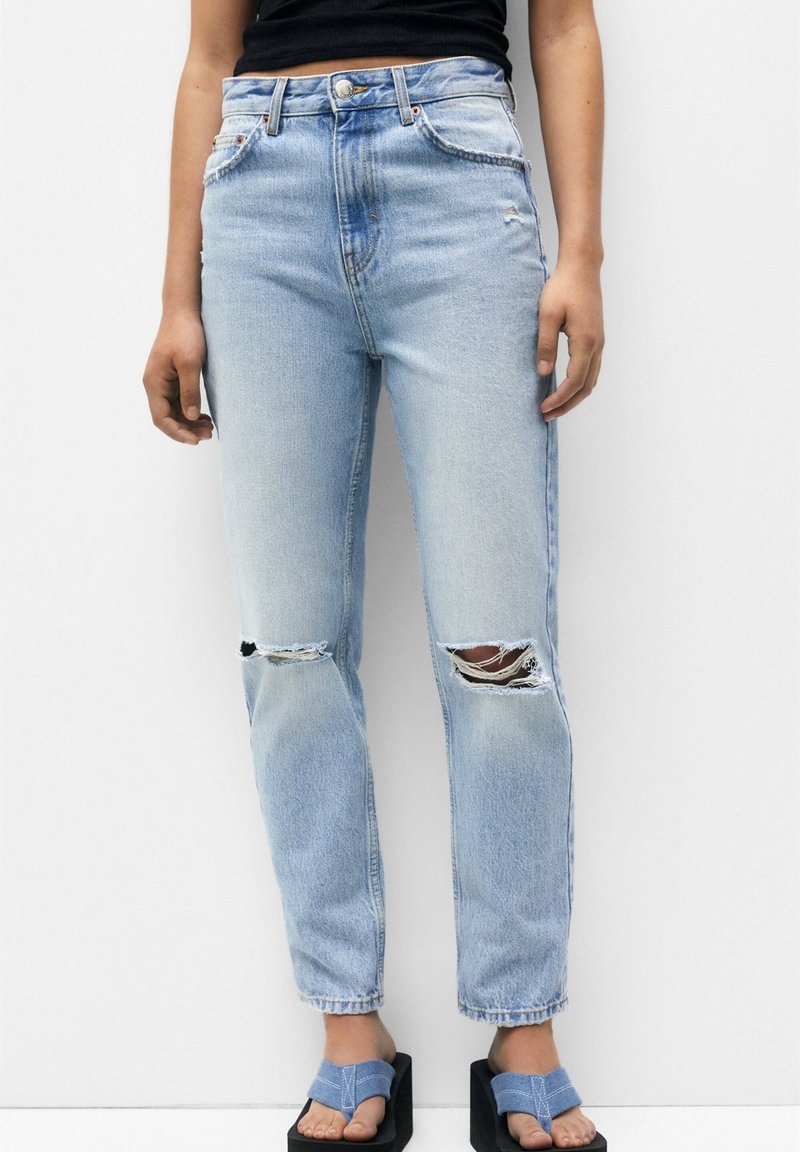 Ljust tvättade denimjeans med hög midja, med slitna knäpartier, rak benpassform och subtila blekningar. Kombinerat med plattformssandaler.
