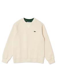 Sudadera de color beige claro hecha de una tela suave, con un cuello redondo, puños de canalé y un pequeño logo verde bordado en el pecho.