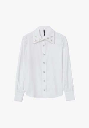Weißes Langarmhemd mit großem Kragen, der mit floralen Verzierungen und perlenähnlichen Details versehen ist, abgerundet mit einer Knopfleiste auf der Vorderseite.